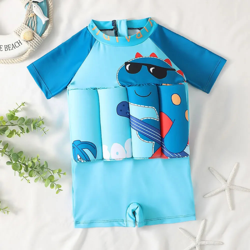 A children's short-sleeve rash guard swimsuit in light blue and teal, featuring a cartoon dinosaur wearing sunglasses and holding a guitar across the chest. The swimsuit is displayed flat on a white fabric background with decorative props including a woven hat, green leaves, and starfish.

