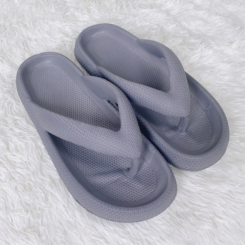 Pair of gray slippers on a white textured surface

