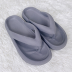 Pair of gray slippers on a white textured surface


