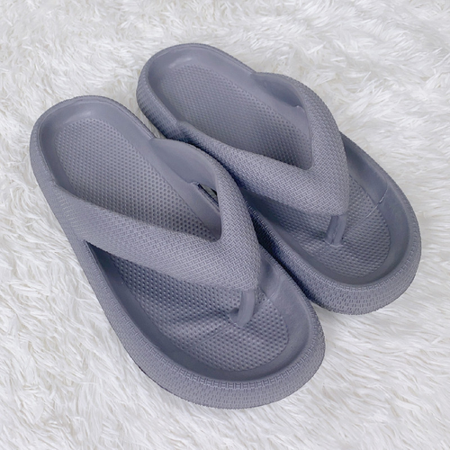 Pair of gray slippers on a white textured surface

