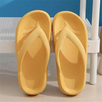 Pair of yellow slippers on a textured surface with a blue background

